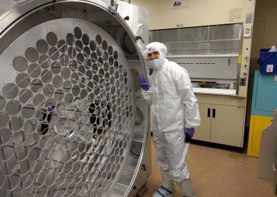 Samuel Chan posing in the Brown cleanroom with an empty PALACE enclosure