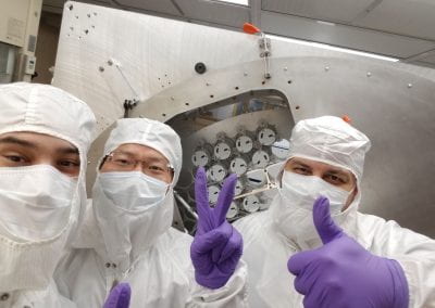 Several Brown workers in the cleanroom, gesturing positively towards the camera
